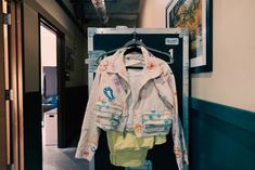 a white jacket hanging on a rack next to a door in a room with blue walls