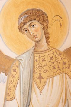 an angel painted on the side of a wall with gold and white wings, holding a cross