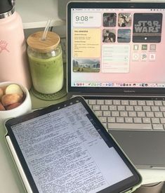 an open laptop computer sitting on top of a desk next to a cup of coffee