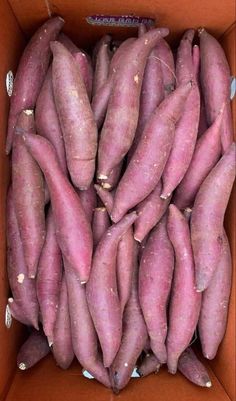 a cardboard box filled with purple sweet potatoes