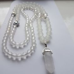 "Totally stunning handmade piece.  Unique Design for that special day.  I have used Selenite beads with accents of silver tone metal and silver foiled glass beads to add Panaz!  Finished with a lovely Quartz Crystal point.  Wonderful long Bridal necklace.  Flapper style. Have something special and different for your big day.  32\" long with 1.5\" quartz pendent.  Supplied in a lovely presentation box." White Adjustable Crystal Necklaces For Spiritual Style, Handmade Bohemian White Crystals, Handmade White Bohemian Crystals, Bohemian Handmade White Crystals, Silver Healing Beaded Jewelry, White Hand-wrapped Round Bead Necklaces, Silver Healing Jewelry With 108 Beads, White Natural Stones Crystals For Spiritual Use, White Gemstone Beads Spiritual Crystal Necklace