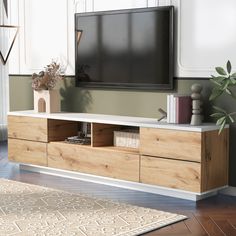 a flat screen tv sitting on top of a wooden entertainment center in a living room