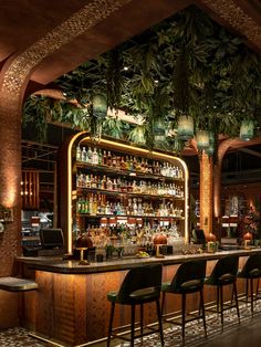 the bar is decorated with tropical plants and hanging lights