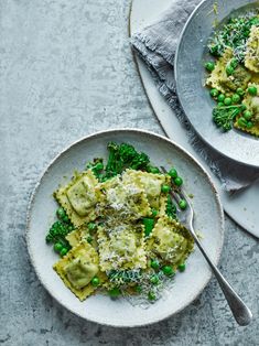 two plates with pasta, peas and parmesan cheese