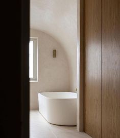 a white bath tub sitting next to a wooden door