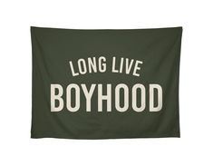 a green wall hanging with the words long live boyhood printed in white on it