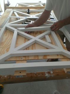 two men working on an unfinished piece of wood