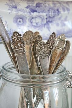 a glass jar filled with lots of silverware