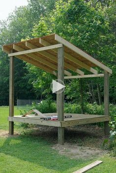 a wooden bed sitting on top of a lush green field