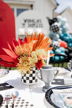 a table set with plates, cups and flowers