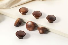 several wooden knobs on a white surface