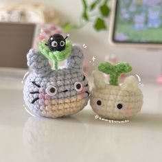 two small crocheted animals sitting next to each other on top of a table