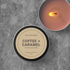 coffee and caramel scented soy candle in a tin next to a lit candle holder