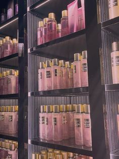 the shelves are filled with many different types of hair care products in pink and gold