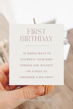 someone holding up a card that says first birthday