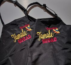 two black totes with the words, female squad and tomales squad on them