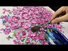 someone is painting pink flowers on a canvas