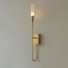 a wall light that is on the side of a wall with a candle in it