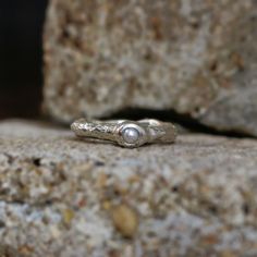 a silver ring sitting on top of a rock