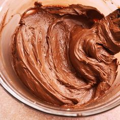 a bowl filled with chocolate frosting on top of a counter