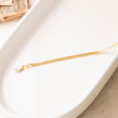 Our 14K Gold Snake Chain Bracelet is the epitome of sleek design and modern luxury. This handcrafted piece, with its distinctive flat snake chain, offers a smooth and comfortable fit, making it perfect for daily wear or special occasions. The high-quality 14K gold construction not only imparts lasting durability but also an undeniably elegant aesthetic. Available in various widths and lengths, this bracelet can be personalized to your exact preference for a snug or more relaxed fit. Key Features Flat Snake Chain, Gold Snake Chain, Elegant Aesthetic, Snake Chain Bracelets, Gold Flats, Gold Snake, Classic Gold, Exquisite Jewelry, Snake Chain