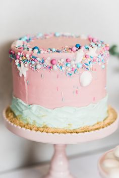 there is a pink cake with sprinkles on it