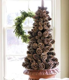 a pine cone christmas tree sitting on top of a window sill next to a couch