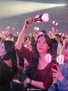 two women holding up hair dryers in front of an audience