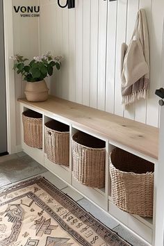 an entryway with baskets on the wall and rug in front of it, next to a bench