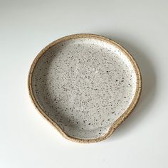 a white and black speckled bowl sitting on top of a table