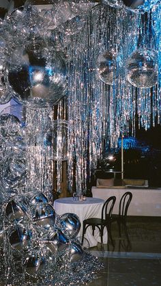 a room filled with lots of shiny glass balls hanging from the ceiling