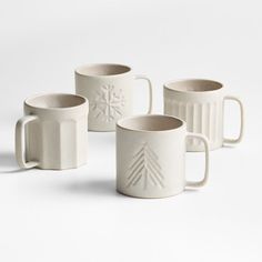 four white mugs sitting next to each other