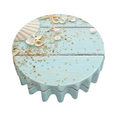 a blue cake with shells and sand on it