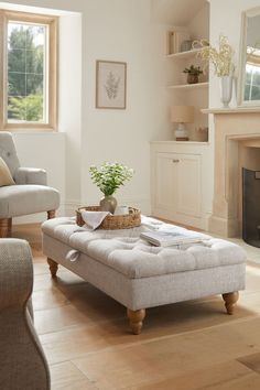 a living room filled with furniture and a fire place next to a window on top of a hard wood floor