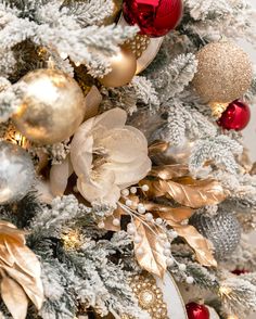 a christmas tree decorated with gold, silver and red ornaments on it's branches