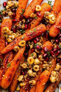 roasted carrots with nuts and cranberries on a white platter, ready to be eaten