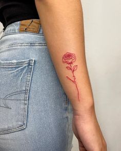 a woman's arm with a rose tattoo on it