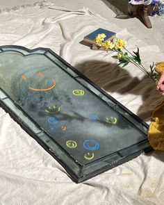 a teddy bear sitting on the ground next to a glass case