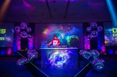 a dj set up in the middle of a room with disco balls on the floor