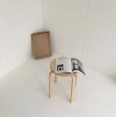 an open book sitting on top of a table next to a small wooden box and chair