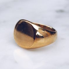 Gold toned glossy Brass Minimal Ring in sizes for both men and women. This simple ring has a circular flat face but lot's of style and flat top rings are definitely in right now! Available in 925 Sterling Silver https://etsy.me/2AZYZkU Ring Size Available in all sizes. Please be sure to find your exact ring size for the finger you want before ordering. See image chart above or you can use the chart on my website as a guide - https://jewelrylab.co/pages/ring-sizing-tips A note about brass jewelry Minimalist Oval Rings With Shiny Finish, Minimalist Dome Ring With Polished Finish And Thick Band, Round Minimalist Jewelry With Polished Edges, Minimalist Dome Ring With Polished Finish, Minimalist Round Jewelry With Polished Edges, Minimalist Rounded Jewelry With Shiny Finish, Modern Shiny Finish Signet Ring, Modern Signet Ring As Gift With Smooth Finish, Modern Rings With Smooth Rounded Finish