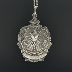 "A magnificent antique Catholic Communion medal, Art Nouveau period French religious holy medal, hallmarked, blank on reverse, in good used condition. A fairly rare religious holy medal, nice size, ideal for protection necklace, would make a nice gift for someone special! Floats from a 22 inch long 925 silver chain! Material: solid silver, hallmarked total weight: 10.5g Measures: approx 26 x 37 mm (1 x 1.5\" inch) A stunning religious shop well worth a visit ... https://etsy.me/2HAqjdY" Commemorative Coin Pendant, Engraved Coin-shaped Spiritual Jewelry And Charms, Miraculous Medal Medallion Necklaces For Commemoration, Miraculous Medal Medallion Necklace For Commemoration, Engraved Spiritual Medallion Jewelry, Engraved Round Pendant For Commemoration, Miraculous Medal Medallion For Commemoration, Spiritual Engraved Medallion Locket Necklace, Silver Engraved Necklace For First Communion