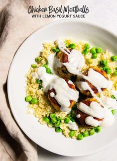 chicken breast with lemon yogurt sauce on top of couscous and peas