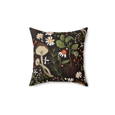 a black pillow with flowers and mushrooms on it