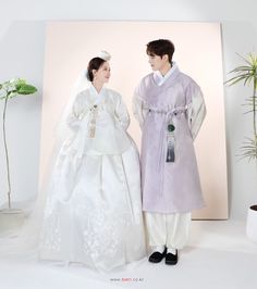 two people standing next to each other in wedding dresses