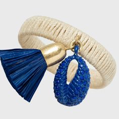 a pair of blue and white bracelets with tassels hanging from the ends