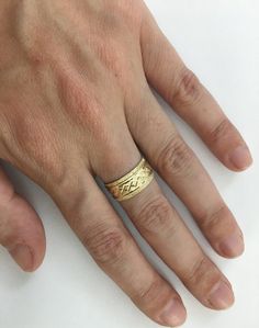 a man's hand with a gold ring on it