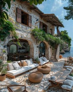 an outdoor living area with couches and tables next to the water's edge