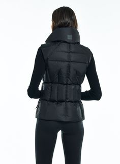 This shaped, channel quilted, down vest is crafted from a densely woven matte nylon. It is filled with down to achieve warmth and an ultra soft feel. The Freedom Vest is lightweight, wind resistant, and water repellent, making it perfect for year-round wear and function. It features a stand collar, center front zip closure, and 2 lower zip pockets. Sleeveless Black Down Outerwear, Fitted Puffer Vest For Cold Weather, Functional Black Vest With Padded Collar, Black Functional Vest With Padded Collar, Fitted Nylon Winter Vest, Down Vest With Padded Collar, Fitted Nylon Vest For Cold Weather, Sleeveless Down Vest With Padded Collar, Black Quilted Nylon Vest