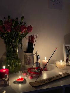 candles and flowers on a table in a dimly lit room